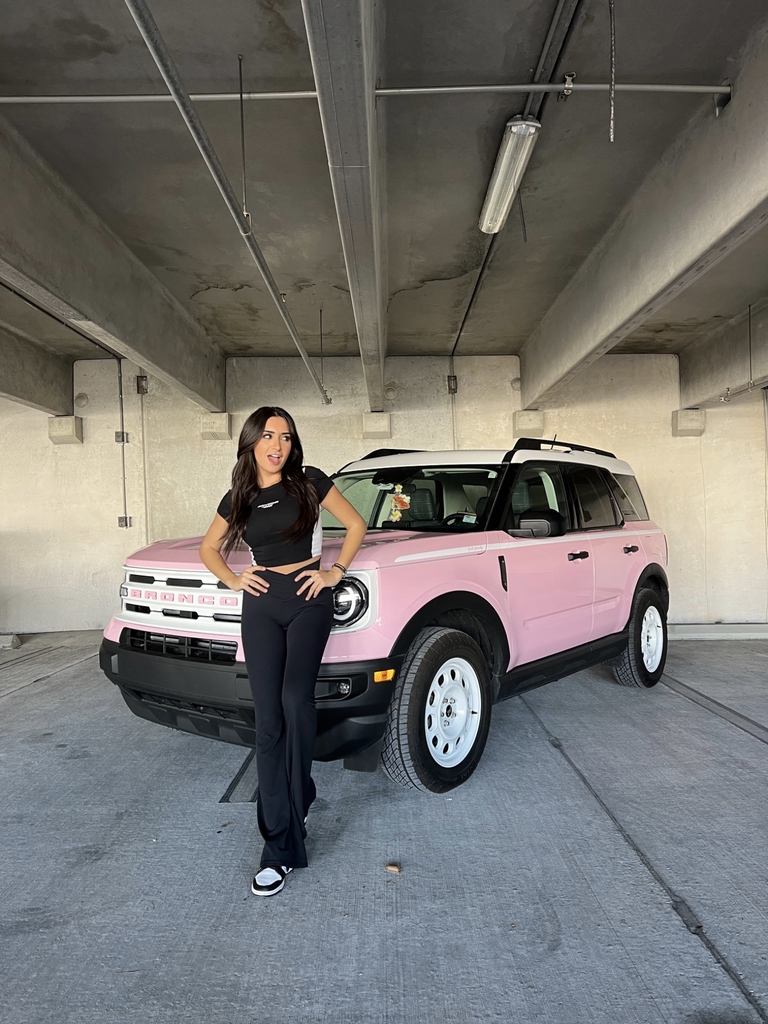 Christina Roki in front of a custom Pink Ford Bronco.